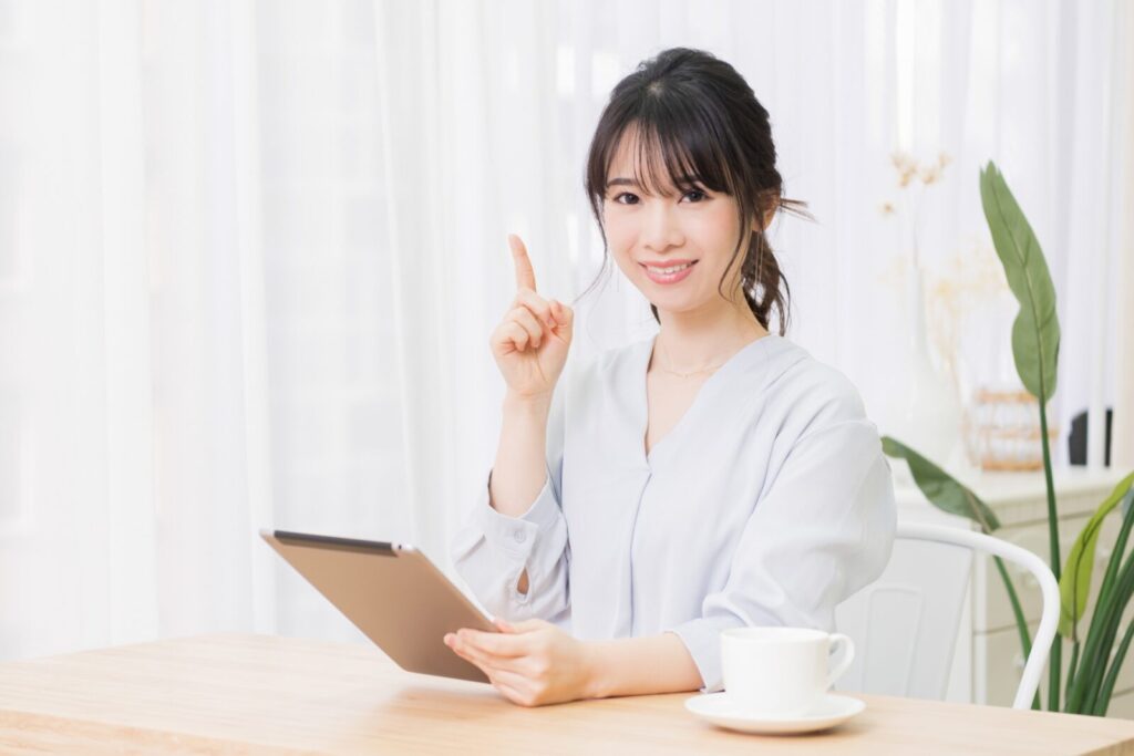 部屋でタブレットを手に持つ笑顔の女性